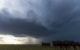 A wide photo of the massive clouds in a "super cell," with a group of cows looking at the camera in the foreground. (Photo by Daniel Rodriguez via Flickr/Creative Commons https://flic.kr/p/nk8YiR)