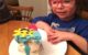 Four year old with a slice of his rainbow cake