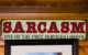 Wall sign: "Sarcasm: One of The Free Services I Offer" (Photo by Thomas Hawk via Flickr/Creative Commons https://flic.kr/p/2i2QWgQ)