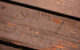 The word "Diggity" carved into a brown wooden picnic table.