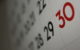 A paper calendar with the days of the month in black. The number 30 is highlighted in red. (Photo by Dafne Cholet via Flickr/Creative Commons https://flic.kr/p/9bUbH3)