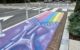 A street mural in Washington DC shows a zipper unzipping seven rows of rainbow-colored blocks, in tribute to the style of painter Alma Thomas. (Photo by Joe Flood via Flickr/Creative Commons https://flic.kr/p/2mfbp3F)