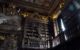 Ornate wooden shelves hold antiquarian books on the mezzanine floor of the Joanina Library, University of Coimbra, Portugal. (Photo by jaime.silva via Flickr/Creative Commons https://flic.kr/p/2noWK1v)