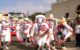 Five people are wearing white masks, hats, capes and suits with the Puerto Rican flag on them, in a parade during the Festival de las Máscaras de Hatillo. (Photo by Joe Delgado via Flickr/Creative Commons https://flic.kr/p/8o96Hg)