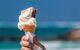 A hand holds an ice cream cone, which is starting to drip. (Photo by sussexcareers via Flickr/Creative Commons https://flic.kr/p/Ui56sx)