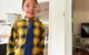 Smiling ten year old in a yellow and black flannel-style shirt and a medium blue necktie.