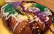 A king cake with Mardi Gras beads on top. (Photo by Phil Denton via Flickr/Creative Commons https://flic.kr/p/bp47Hh)